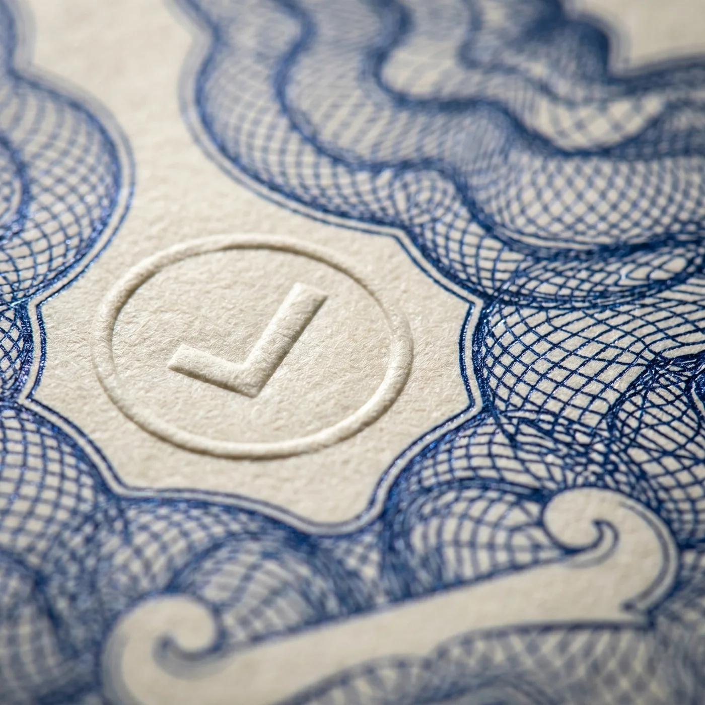 A macro view of guilloche security-paper engraving in cream and cobalt