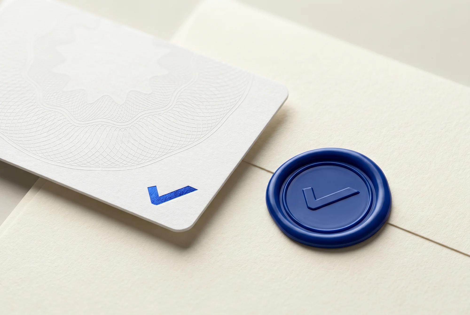 An embossed white identity card with a blue foil check mark beside a wax seal